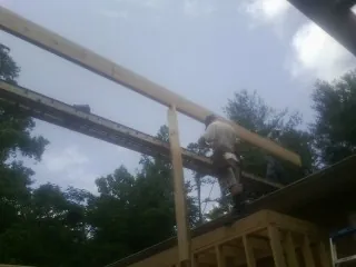 Carpenter setting a ridge beam over a new addition frame — Ice Dam Removal by Roofing Brothers in Venango