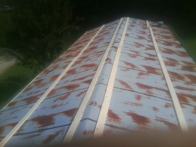 Rusted metal roof panels with new wood purlins before replacement — Storm Damage Roof Repair in Venango by Roofing Brothers