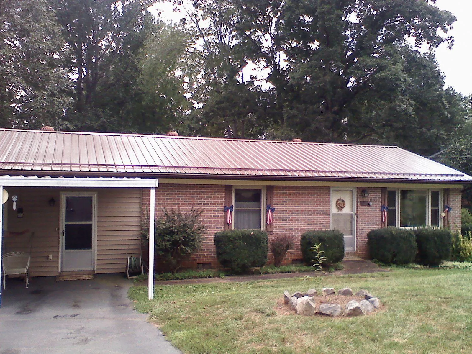 Bronze metal roof and carport on a brick ranch home — Roof Repair work by our crew in Venango